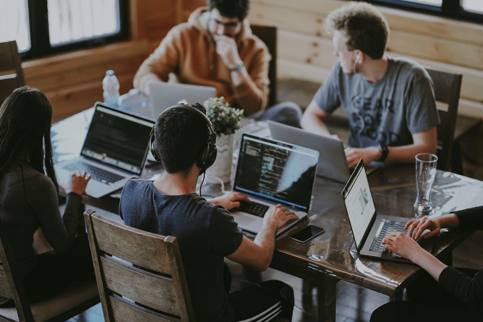 A team of engineers collaborating on laptops around a table